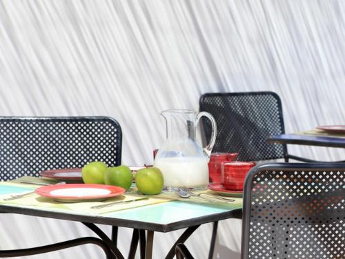 a table with apples and a glass pitcher of milk at Hotel Giardino Giamperduto in Bernalda