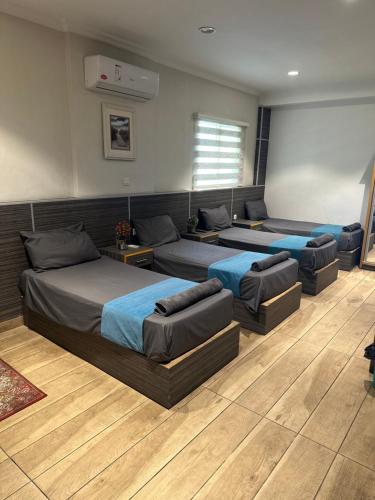 una camera con tre letti e divani di ArwaHotel Apartments اروى للشقق الفندقية ad Aqaba