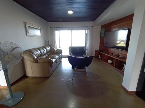 a living room with a couch and a television at Chacras del mar in Mar Azul