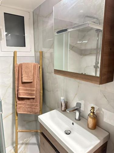 a bathroom with a sink and a mirror at A modern apartment by the sea in Xylokastro