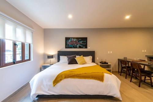 a bedroom with a large bed and a dining room at LOVELY LOFT IN COYOACÁN (FRIDA) by M&I in Mexico City