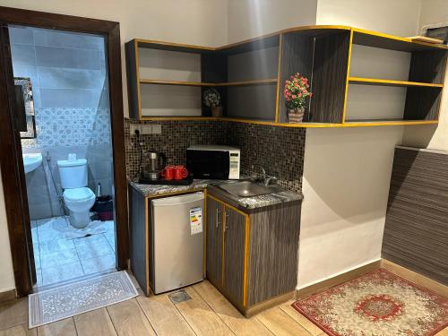 una pequeña cocina con lavabo y aseo en ArwaHotel Apartments اروى للشقق الفندقية en Áqaba