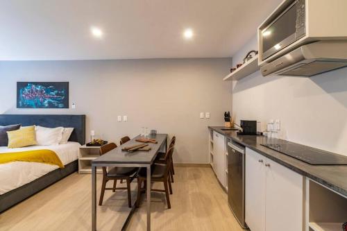 a kitchen and a bedroom with a bed and a table at LOVELY LOFT IN COYOACÁN (FRIDA) by M&I in Mexico City