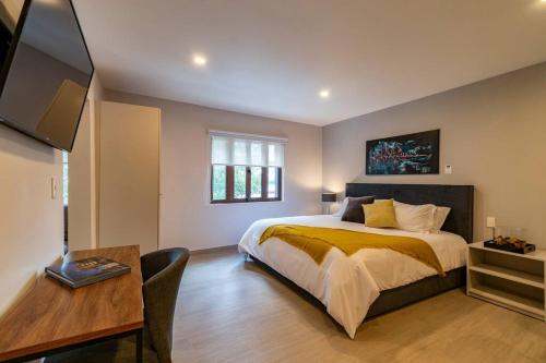 a bedroom with a bed and a table and a desk at LOVELY LOFT IN COYOACÁN (FRIDA) by M&I in Mexico City