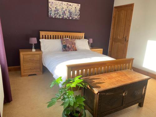 a bedroom with a bed and a bench and a painting at Belle Vue, 5 bedroom house in Cockermouth