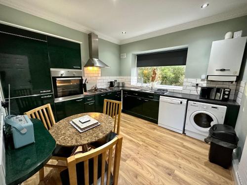 a kitchen with a table and a dining room at Roker Cottage, luxury seaside apartment, private parking, sky tv in Sunderland