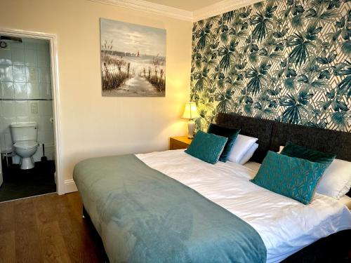 a bedroom with a large bed with blue pillows at Roker Cottage, luxury seaside apartment, private parking, sky tv in Sunderland