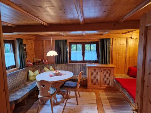 a living room with a couch and a table and chairs at Holzfällerhaus Melkstatt in Auffach