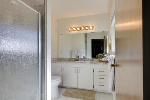 a bathroom with a sink and a toilet and a mirror at Cabin with Deck Located in The Sherwood Forest! in Twain Harte