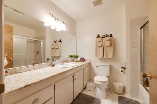 a bathroom with a sink and a toilet and a mirror at Furnished Deck and Fire Pit Sherwood Forest Cabin in Twain Harte