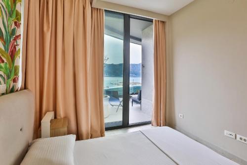 a bedroom with a bed and a window with a view at Royal Gardens Paradise in Budva