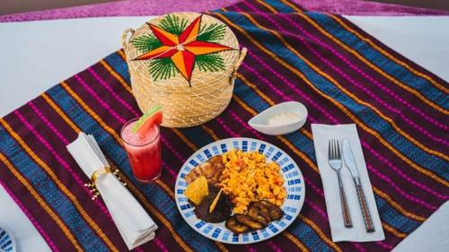 a table with a plate of food and a basket with a straw at Hotel Posada Stella Maris in Puerto Barrios