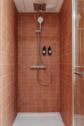 La salle de bains est pourvue d'une douche avec du carrelage orange. dans l'établissement Hôtel Arago - Entrée autonome, réception en ligne - Encore Mieux, à Orléans