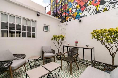 a patio with chairs and tables and a mural at LOVELY LOFT COYOACAN (DIEGO) in Mexico City