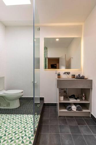 a bathroom with a toilet and a glass shower at LOVELY LOFT COYOACAN (DIEGO) in Mexico City