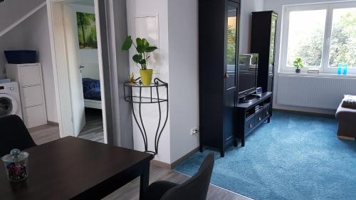 a living room with a table and a room with a tv at FeWo Steingasse in Schwalmstadt