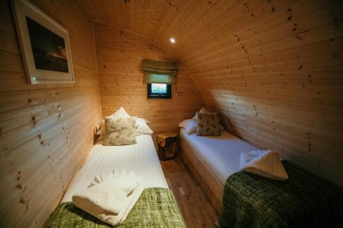 a room with two beds in a wooden cabin at Modulog 1 in Yarmouth