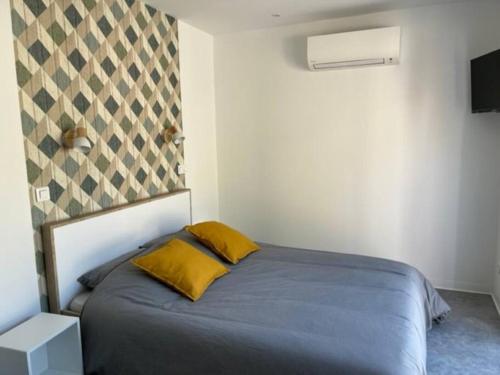 Un dormitorio con una cama con dos almohadas amarillas. en Come à la maison!, en Coupvray