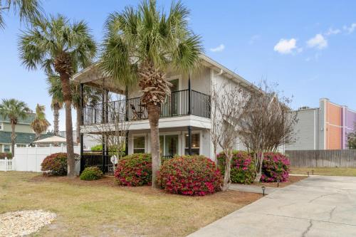 a white house with palm trees and bushes at Serenity Cottage - Spacious Haven - Private Pool in Destin