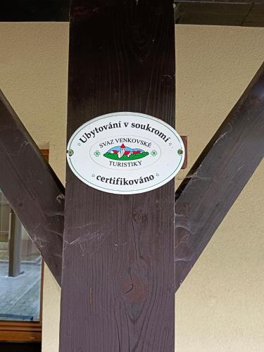a sign on top of a wooden pole at Penzion Mia in Dolní Moravice
