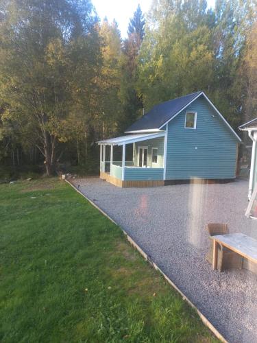 a blue house with a bench in front of it at Fritidshus Hammare Hagfors in Hagfors