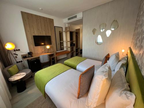 una camera d'albergo con due letti e un soggiorno di Hotel Ben Batouta - Tanger a Tangeri