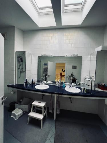 a bathroom with two sinks and a large mirror at Panoramahaus am Ammersee I Sauna I Wellness I Kamin in Herrsching am Ammersee