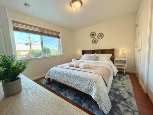 ein Schlafzimmer mit einem großen Bett und einem Fenster in der Unterkunft 9AM Check-in Coastal Getaway - Luxe Suite near Cliff, Lake & Local Shops in Daly City