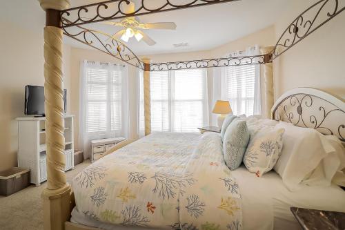 ein Schlafzimmer mit einem Himmelbett und einem TV in der Unterkunft Desoto 305 Seaside Bliss in Tybee Island