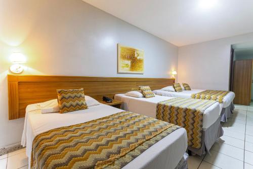 Hotel Golden Park Rio de Janeiro Aeroporto في ريو دي جانيرو: غرفه فندقيه سريرين في غرفه