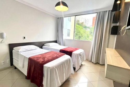 um quarto de hotel com duas camas e uma janela em Apto Flat no Morumbi com Vista Incrível ! em São Paulo