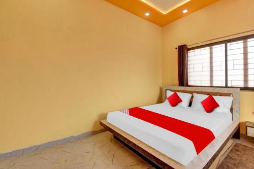 a bedroom with a bed with red and white pillows at Flagship The Heart Residency in Rāmgarh