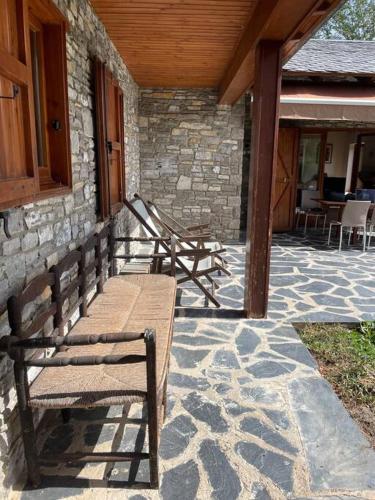two wooden benches sitting on a stone patio at Cal Fray, San Martí d'Aravó, Puigcerdà in Guils de Cerdaña