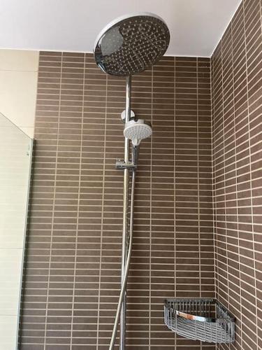 a shower in a bathroom with a brown tiled wall at Cal Fray, San Martí d'Aravó, Puigcerdà in Guils de Cerdaña