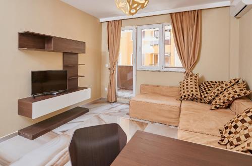 a living room with a couch and a tv at Botabara Del Mar Boutique in Pomorie