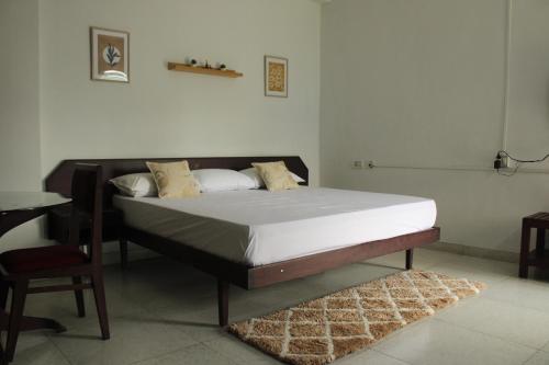 a bed in a room with a table and a chair at Noor Plaza in Angamali