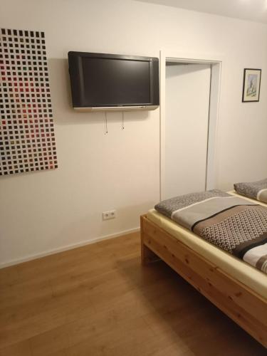 a bedroom with a bed and a flat screen tv on the wall at Sylvis Home Zentral gelegenes Ferienhaus in ruhiger Lage in Fürth