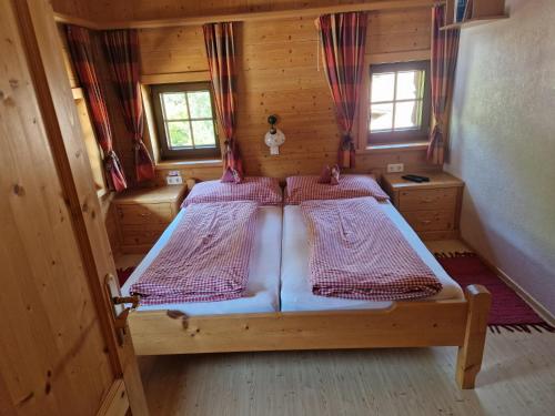 a bedroom with two beds in a wooden cabin at Holzfällerhaus Melkstatt in Auffach