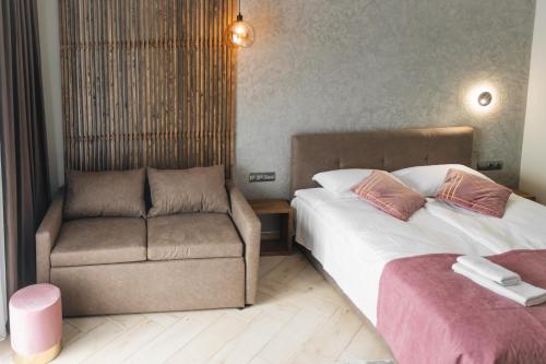 a hotel room with two beds and a chair at Садиба Казка in Vizhenka