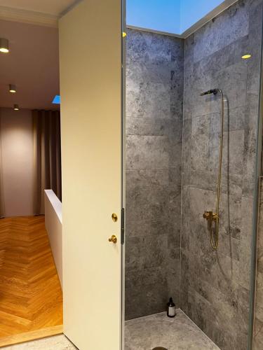 a shower with a glass door in a bathroom at Boutique City Apartment Aarhus in Aarhus