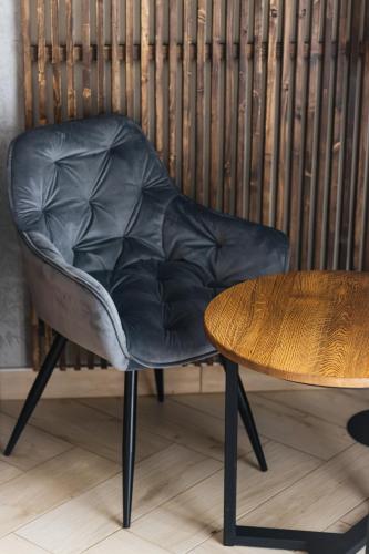 a black leather chair sitting next to a wooden table at Садиба Казка in Vizhenka