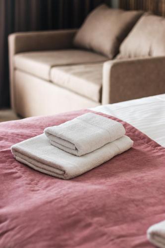 a pile of towels sitting on top of a bed at Садиба Казка in Vizhenka