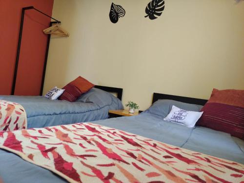 a bedroom with two beds and a comforter at Cabañas Ventalia in El Calafate
