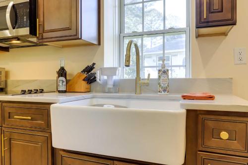 uma cozinha com um lavatório branco e uma janela em Fayetteville Guest House Walk to Nature Preserve! em Fayetteville
