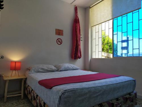 a bedroom with a large bed and a window at Casa Almendros in Cartagena de Indias