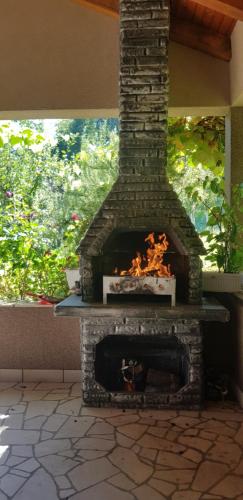 a brick fireplace with a fire inside of it at VA Vikendica in Tešanj