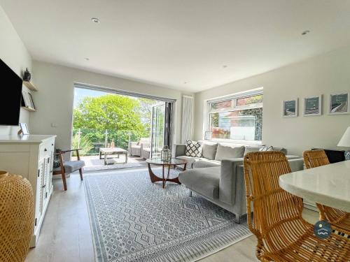 a living room with a couch and a table at Seafeathers - Luxury Holiday Home with Sea Views in Overcombe