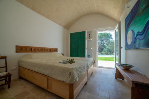 una camera con un grande letto e una grande finestra di trullo la specchia private pool and satellite wifi a San Michele Salentino