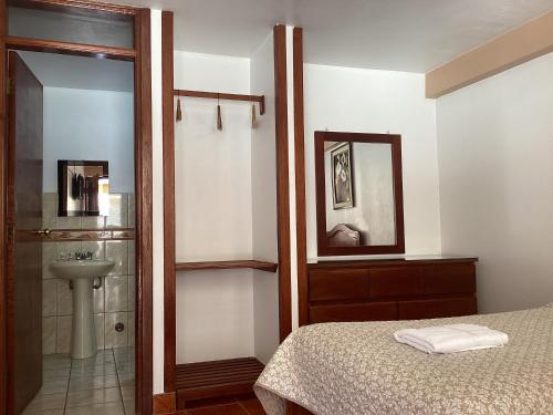 1 dormitorio con cama, lavabo y ducha en Las Torrecitas, en Carhuaz