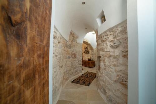 un corridoio di una casa con un muro di pietra di trullo la specchia private pool and satellite wifi a San Michele Salentino